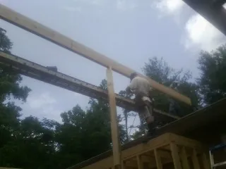 Carpenter setting a ridge beam over a new addition frame — Ice Dam Removal by Roofing Brothers in Du Bois