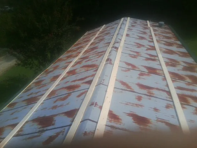 Rusted metal roof panels with new wood purlins before replacement — Storm Damage Roof Repair in Du Bois by Roofing Brothers