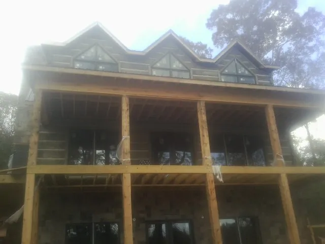 Dormers and porch framing on a large log home under construction — Roof Coating work by our crew in Du Bois