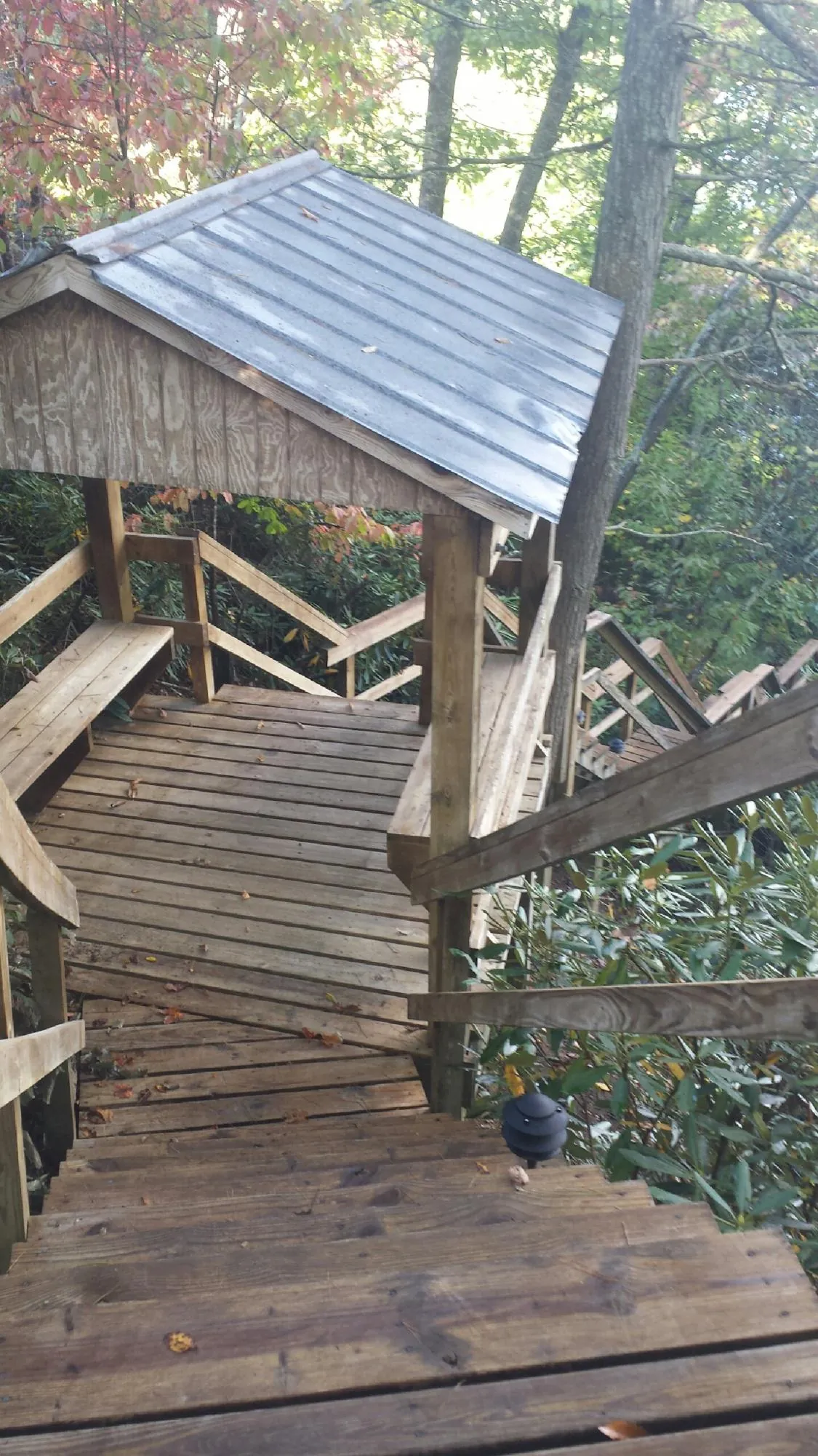Metal roofed shelter over wooden steps on a wooded walkway — Skylight Repair & Installation work by our crew in Du Bois