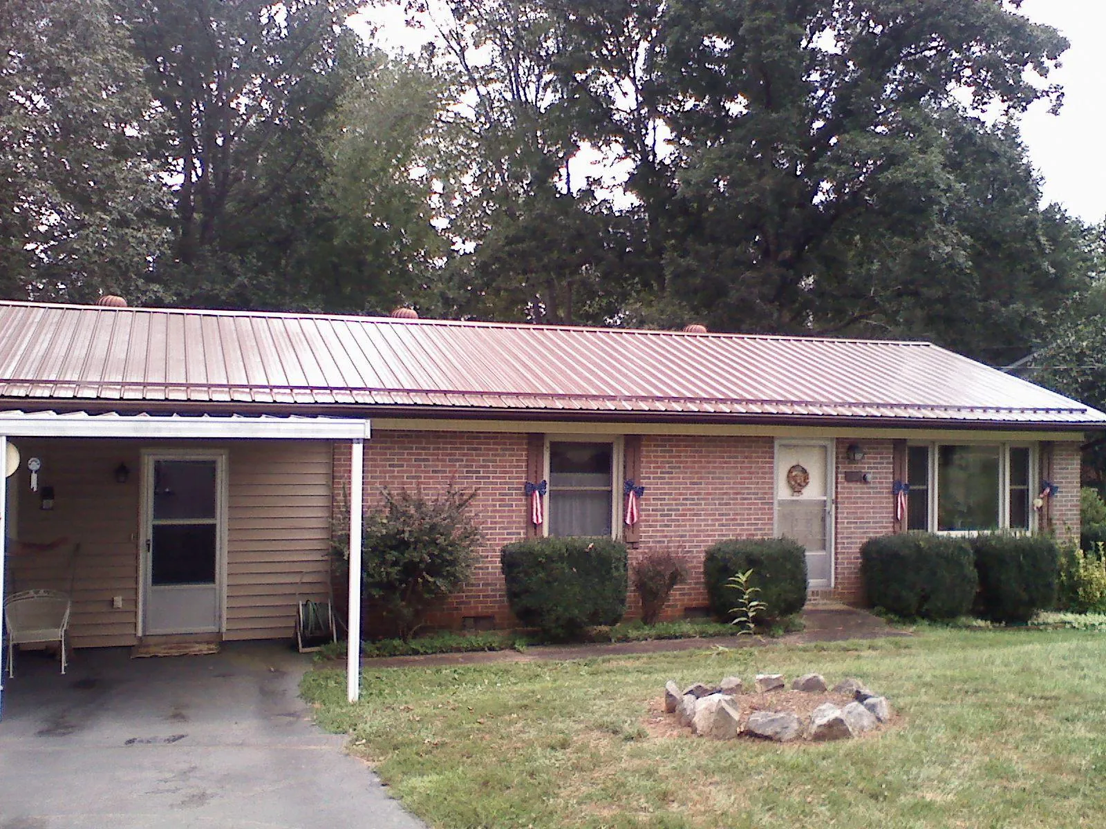 Bronze metal roof and carport on a brick ranch home — Roof Repair work by our crew in Du Bois